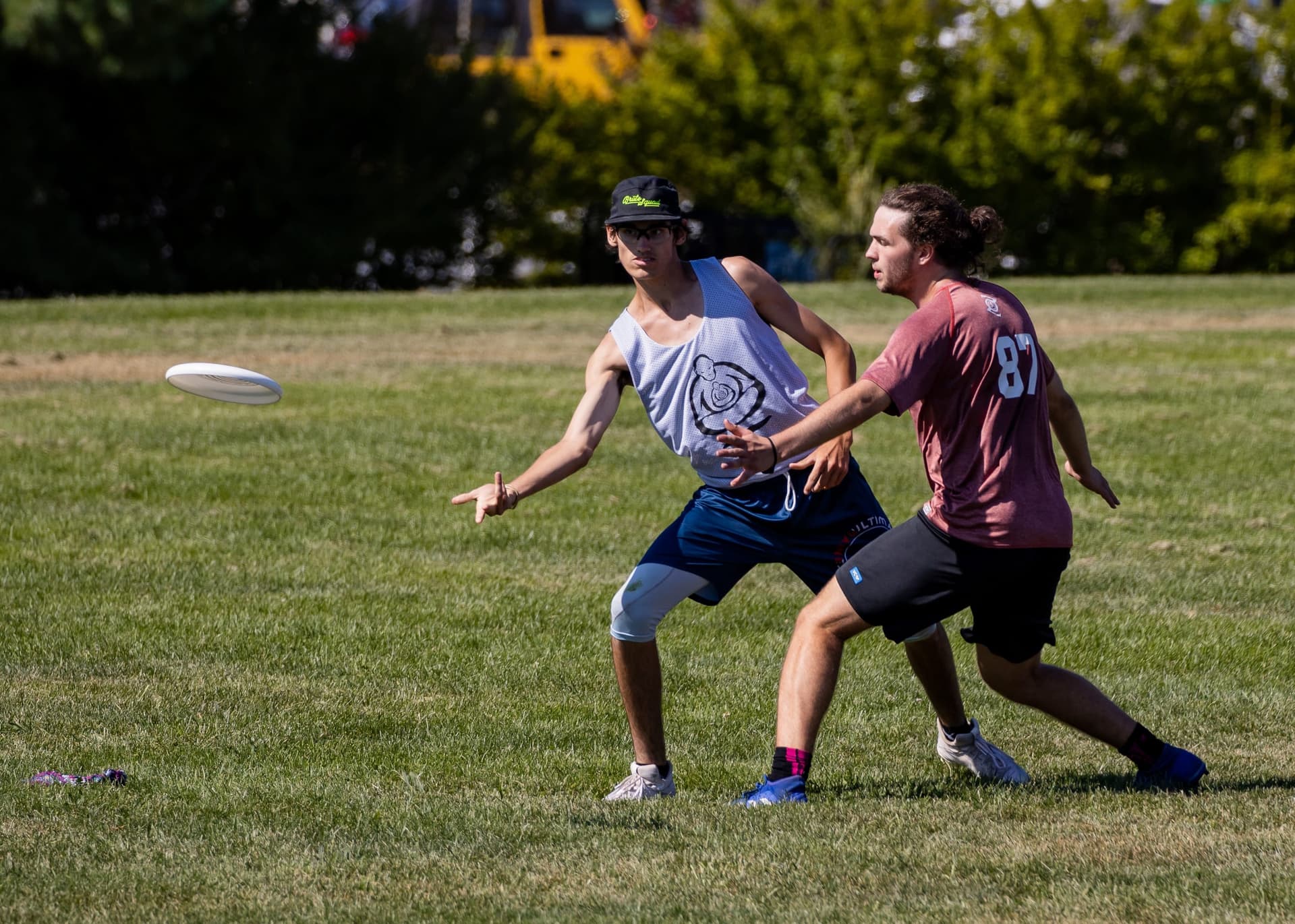 High-school marker pressuring a thrower faking around the force on a sunny field