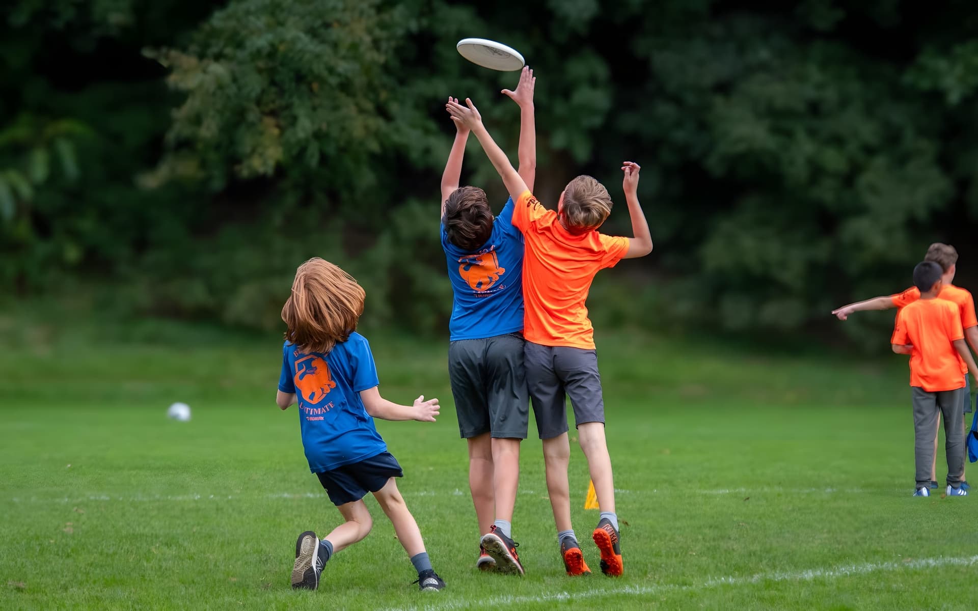 Three elementary-age kids leaping together for a floating disc